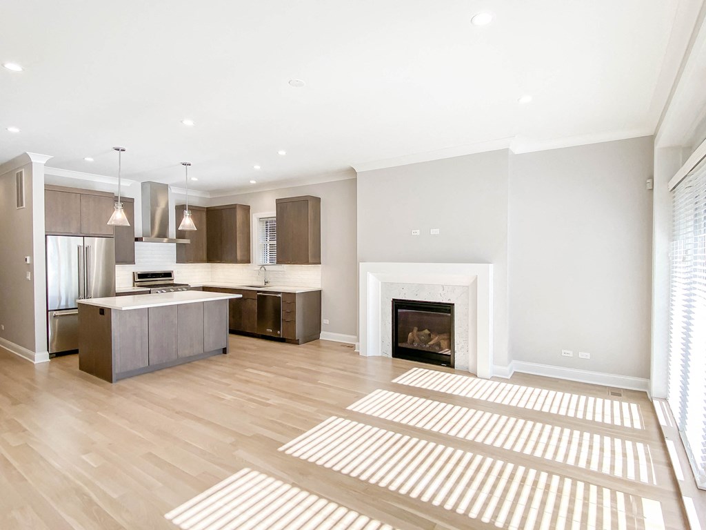 a living room with a fireplace and a kitchen