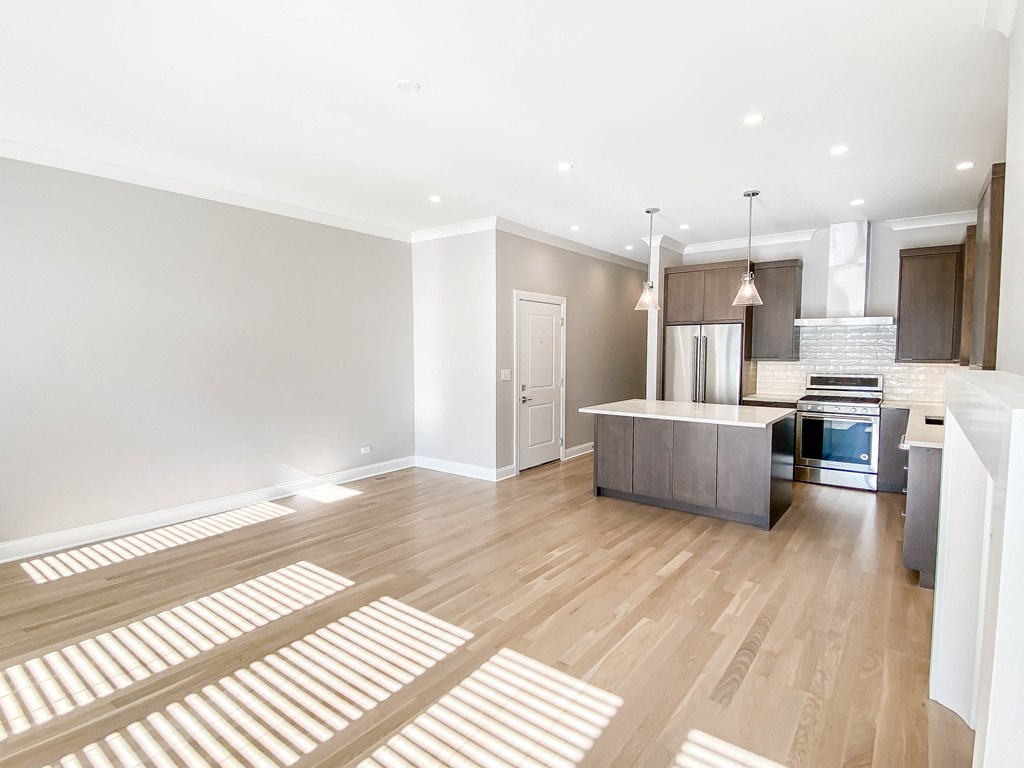 a renovated living room and kitchen with a wooden floor