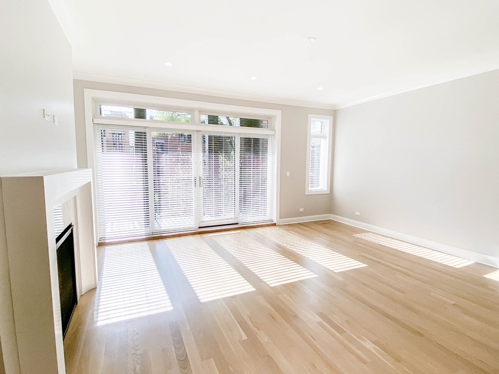 an empty living room with a fireplace and a large window