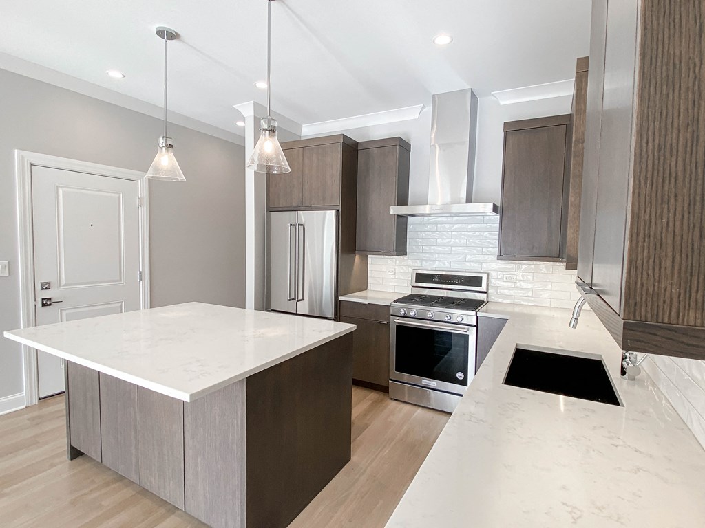 a kitchen with an island and a stove and a refrigerator