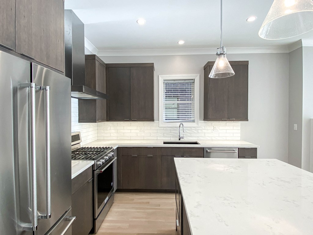 a large kitchen with stainless steel appliances and marble counter tops