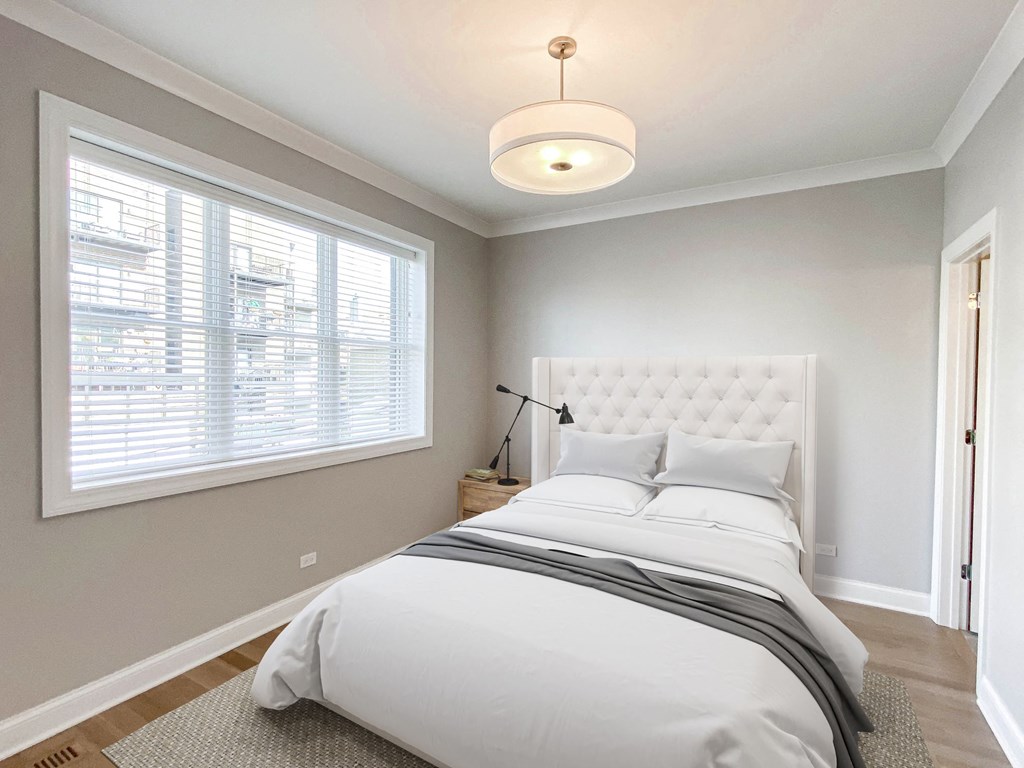 the master bedroom has a large window and a white bed