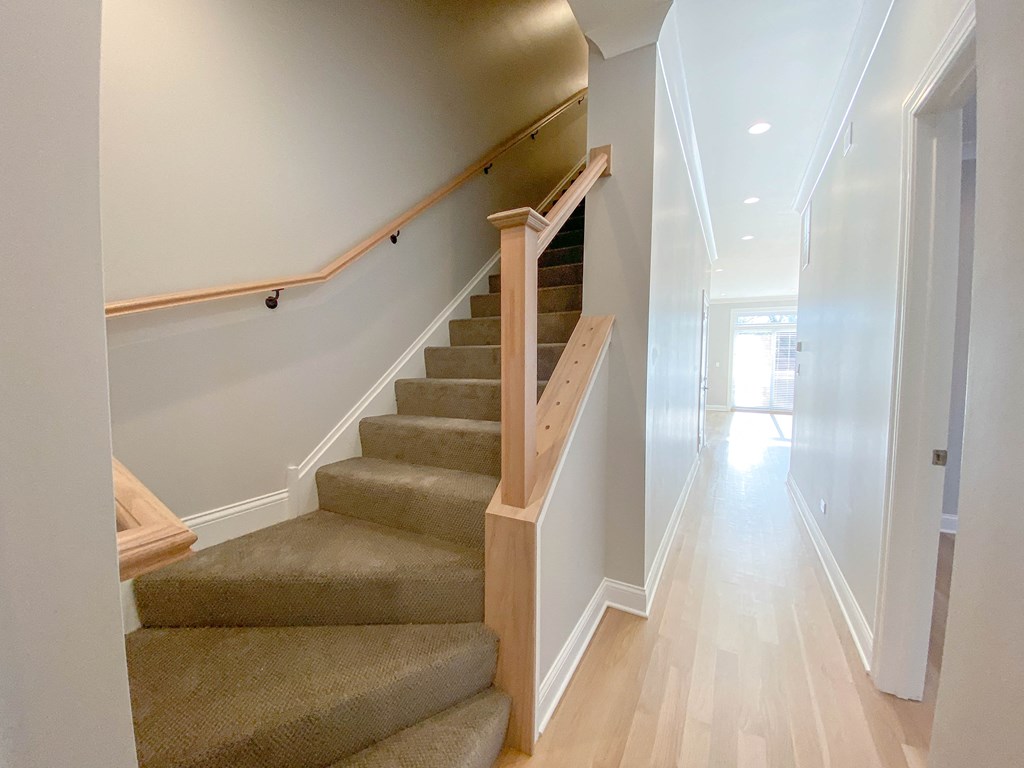 a staircase in a home with carpeted stairs and a hallway with white walls