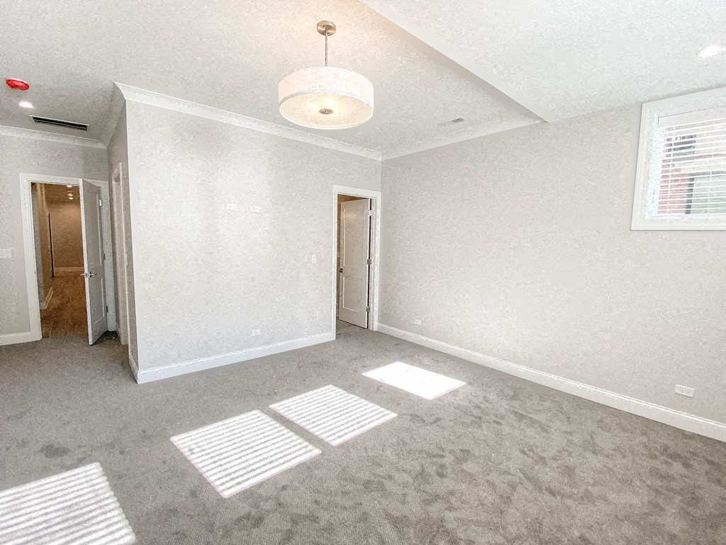 an empty living room with white walls and a ceiling lamp