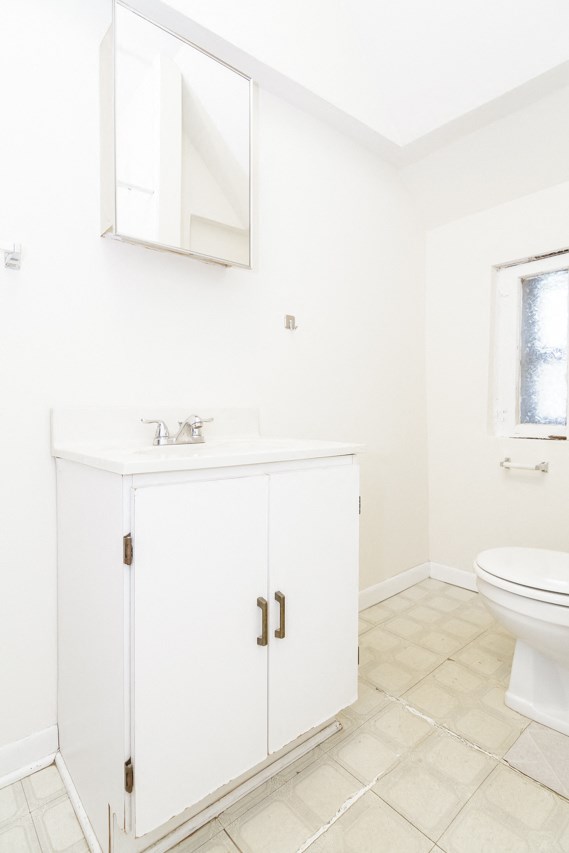 a white bathroom with a sink and a toilet