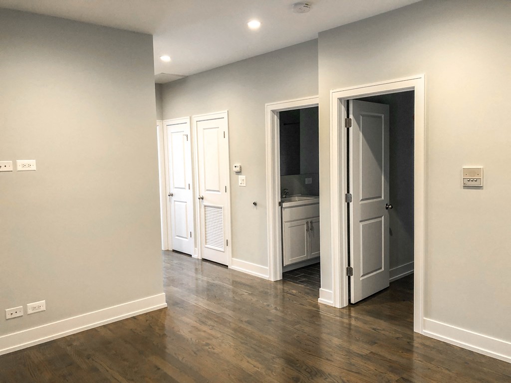 a living room with grey walls and a door to a bathroom