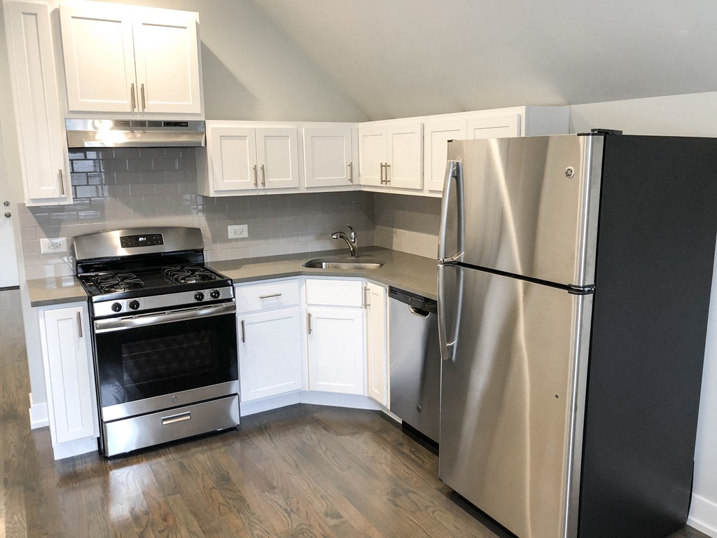 a kitchen with stainless steel appliances and white cabinets