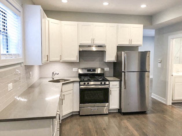 a kitchen with stainless steel appliances and white cabinets
