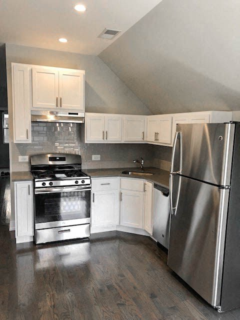 a kitchen with stainless steel appliances and white cabinets