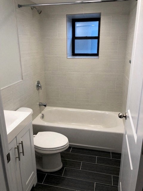 a white bathroom with a toilet and a bath tub