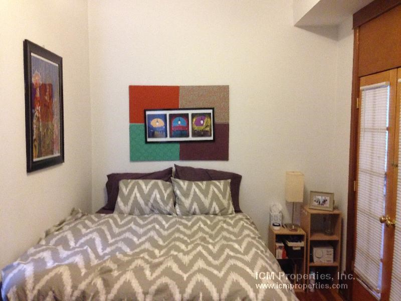 a bedroom with a bed and a painting on the wall