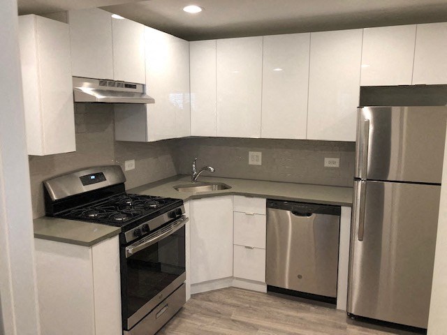 a kitchen with white cabinets and a stainless steel refrigerator