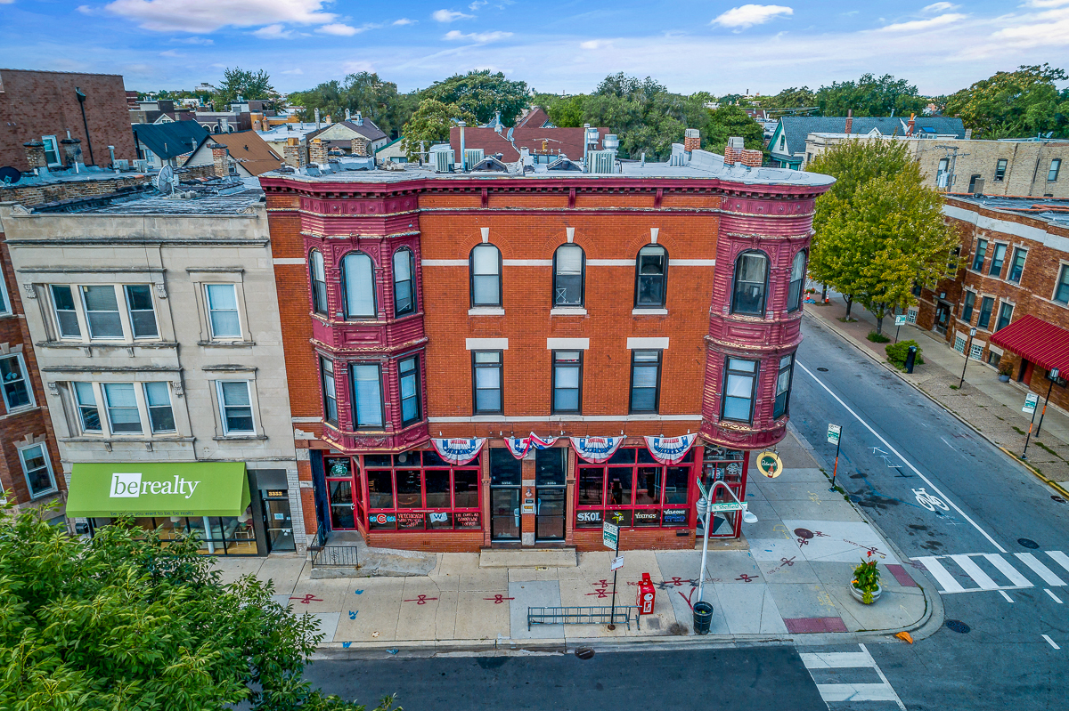 an aerial view of a red brick building on a city street
