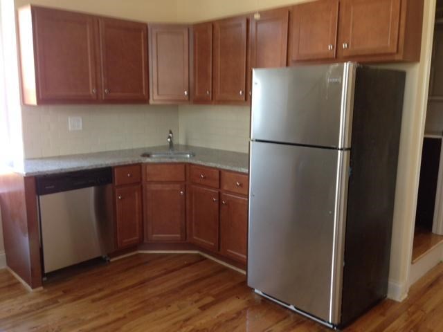 a kitchen with a stainless steel refrigerator and wooden cabinets