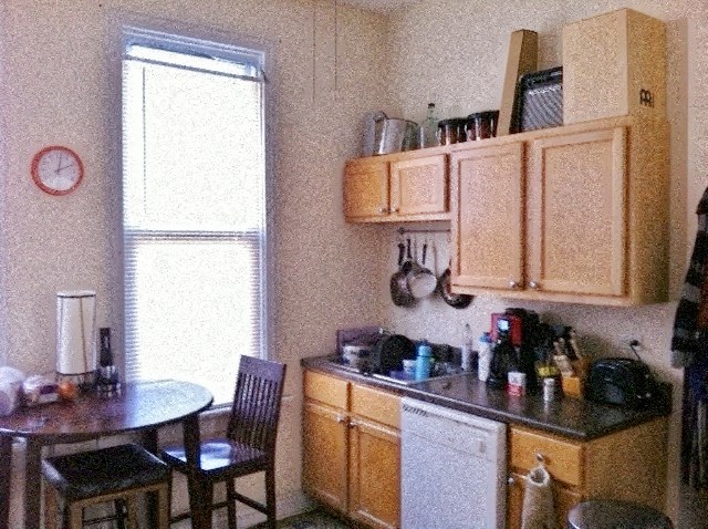 a kitchen with wooden cabinets and a table and chairs