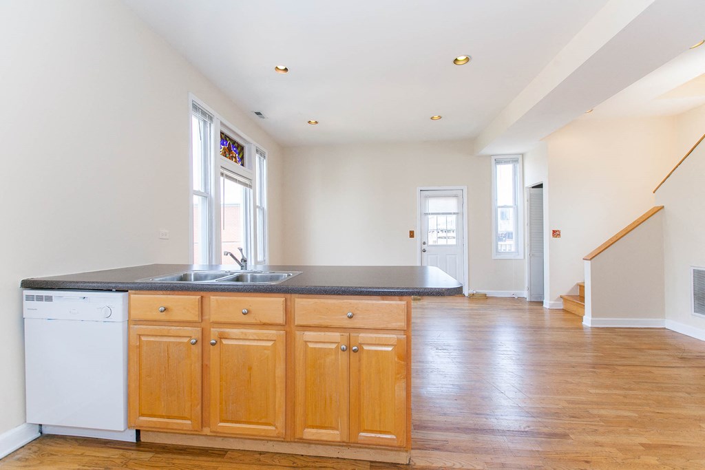 a kitchen with wooden cabinets and a white dishwasher