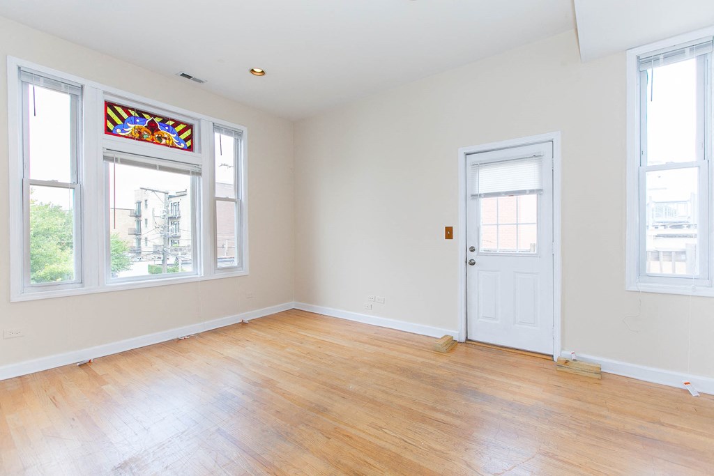 a living room with a wooden floor and a white door