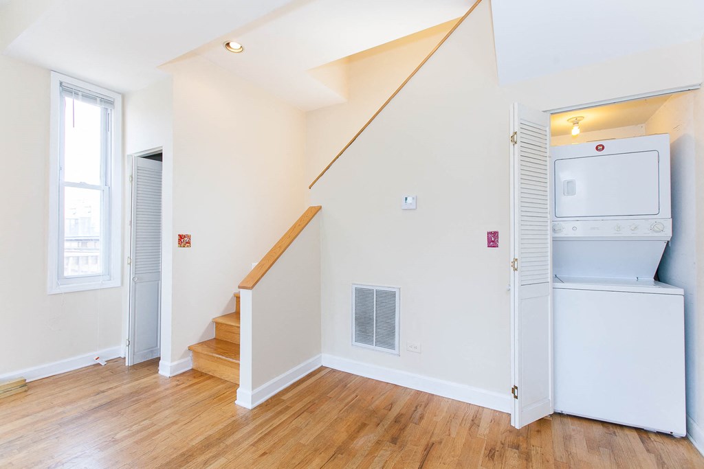 a renovated living room with a washer and dryer and stairs