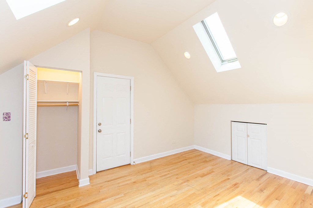 a renovated living room with a vaulted ceiling and wood floors