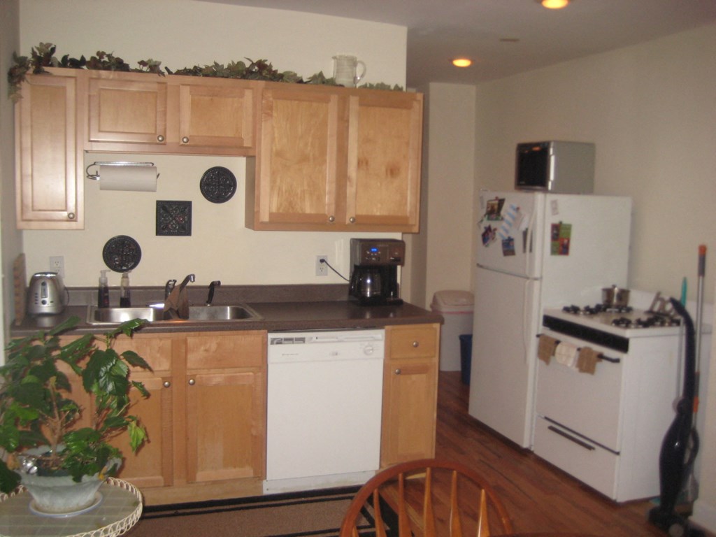 a kitchen with white appliances and wooden cabinets