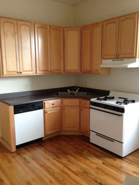 a kitchen with white appliances and wooden cabinets