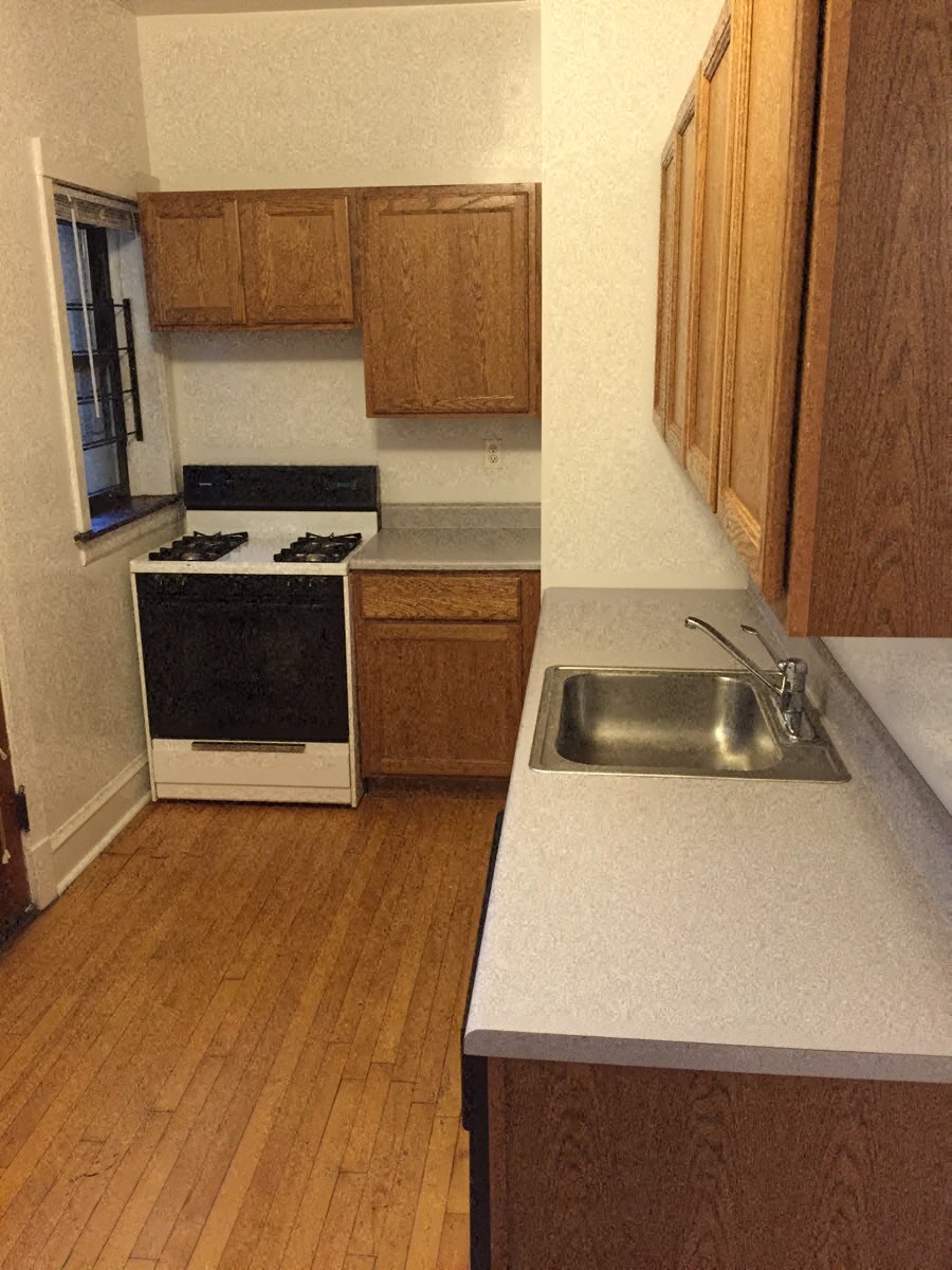 an empty kitchen with a sink and a stove