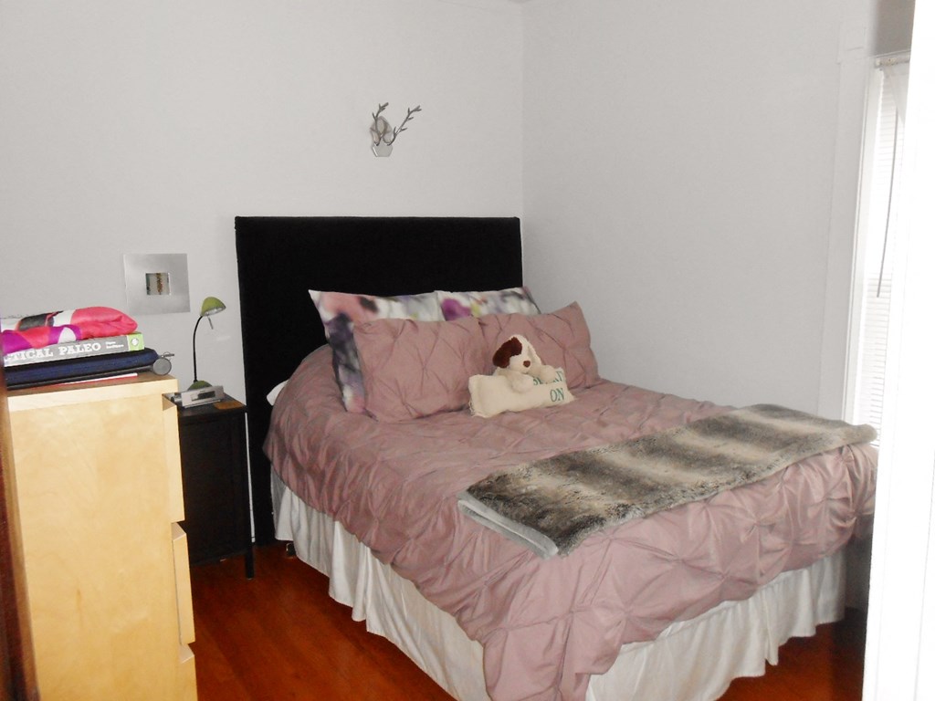 a bedroom with a pink bed and a stuffed animal on it