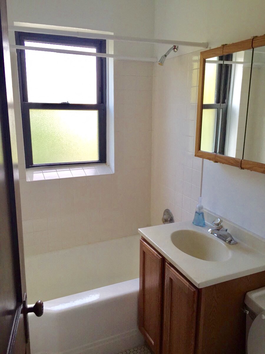a bathroom with a sink and a bath tub and a window