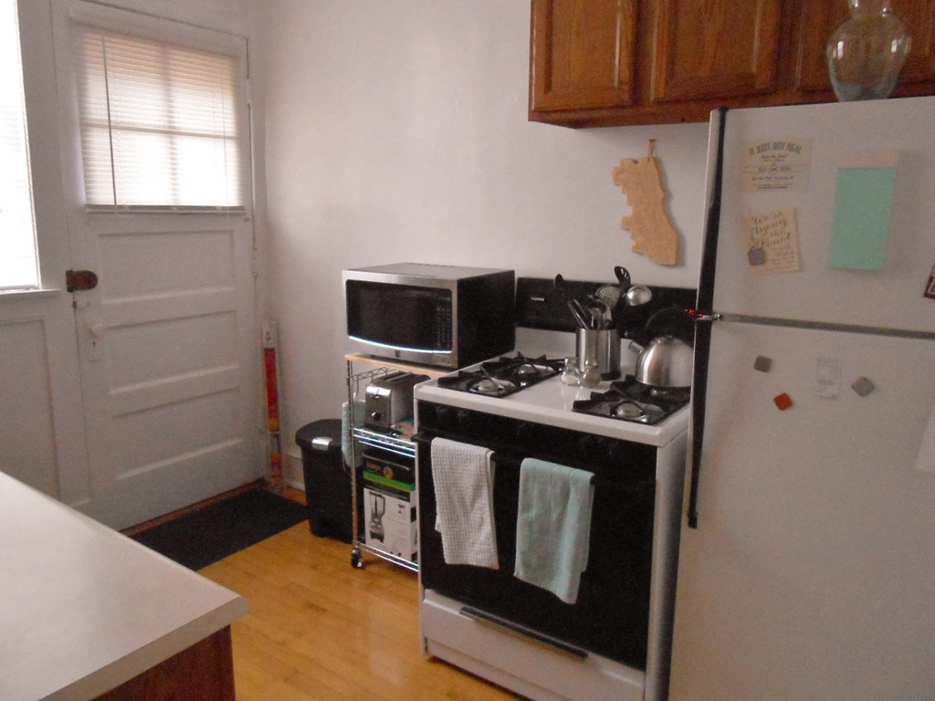 a small kitchen with a stove microwave and refrigerator