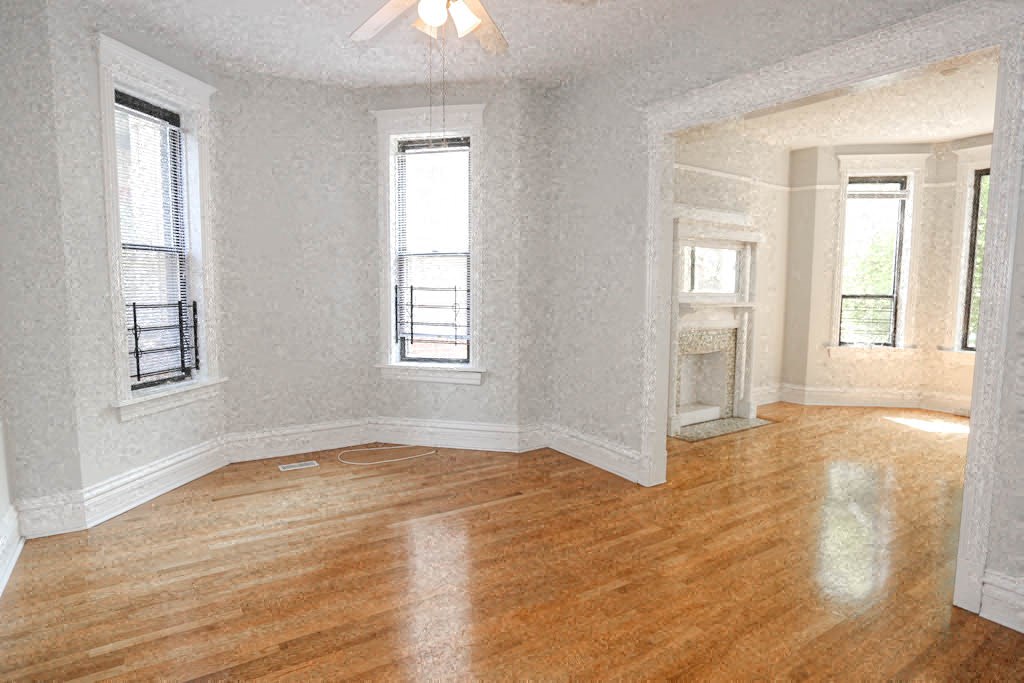 an empty living room with wood floors and windows