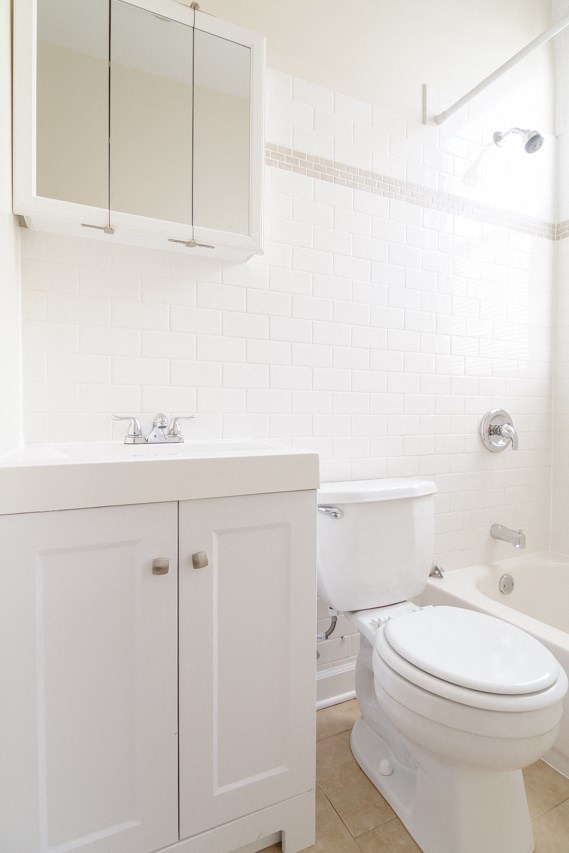 a white bathroom with a toilet and a sink