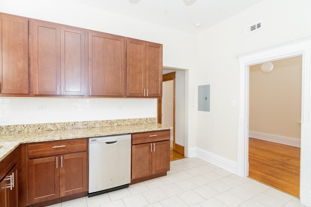 a kitchen with wooden cabinets and a counter top and a dishwasher