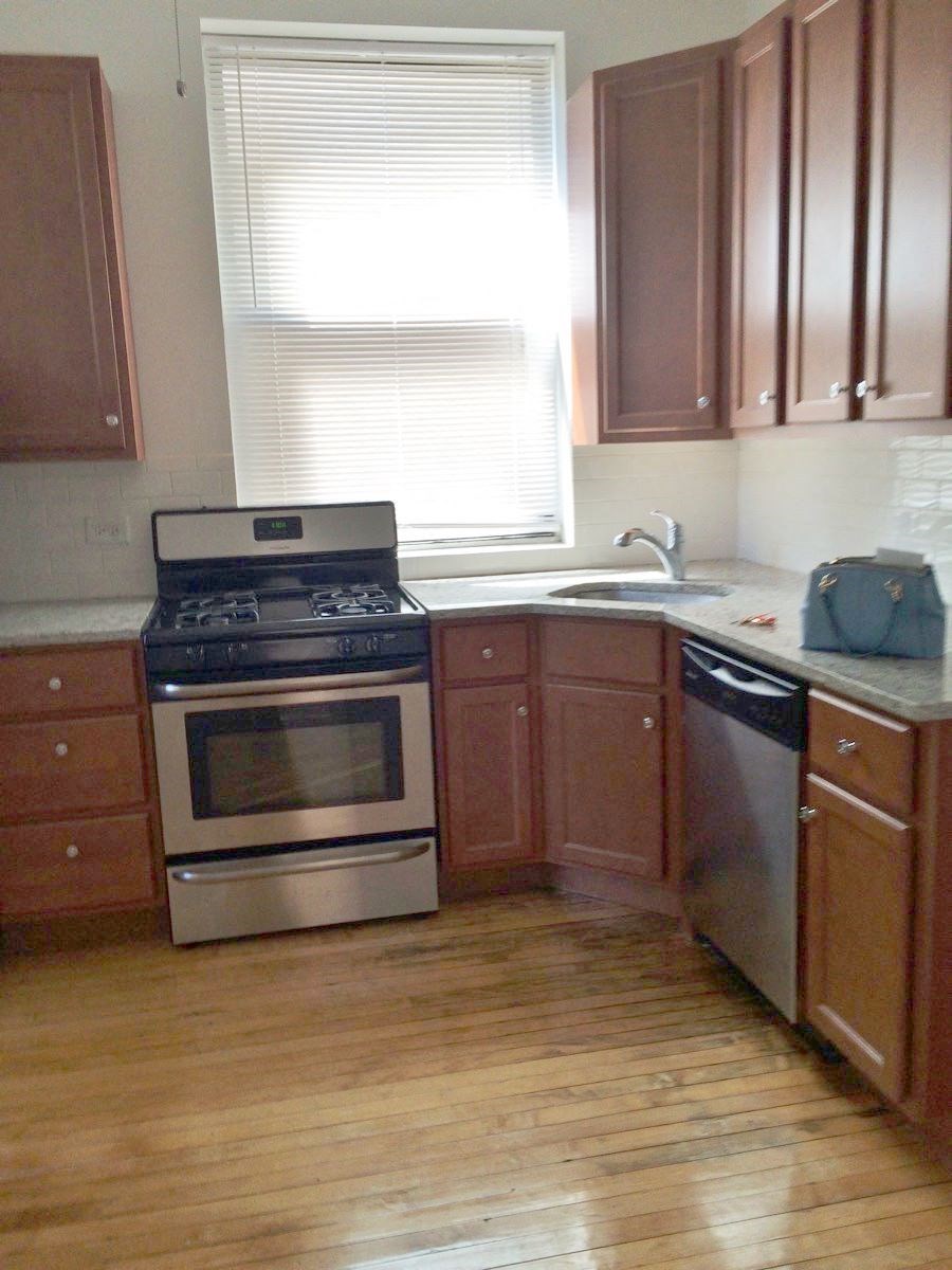 an empty kitchen with a stove and a sink