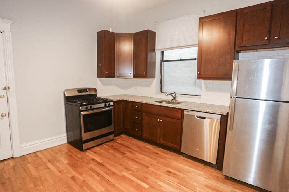 a kitchen with wooden floors and stainless steel appliances