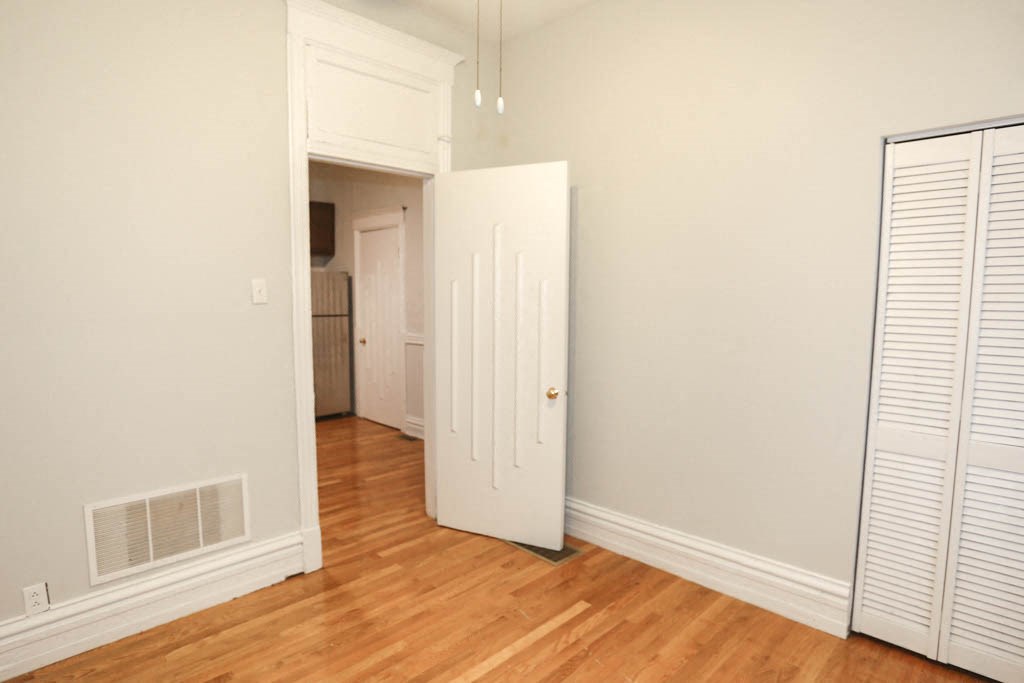 a bedroom with a closet and a door to a hallway
