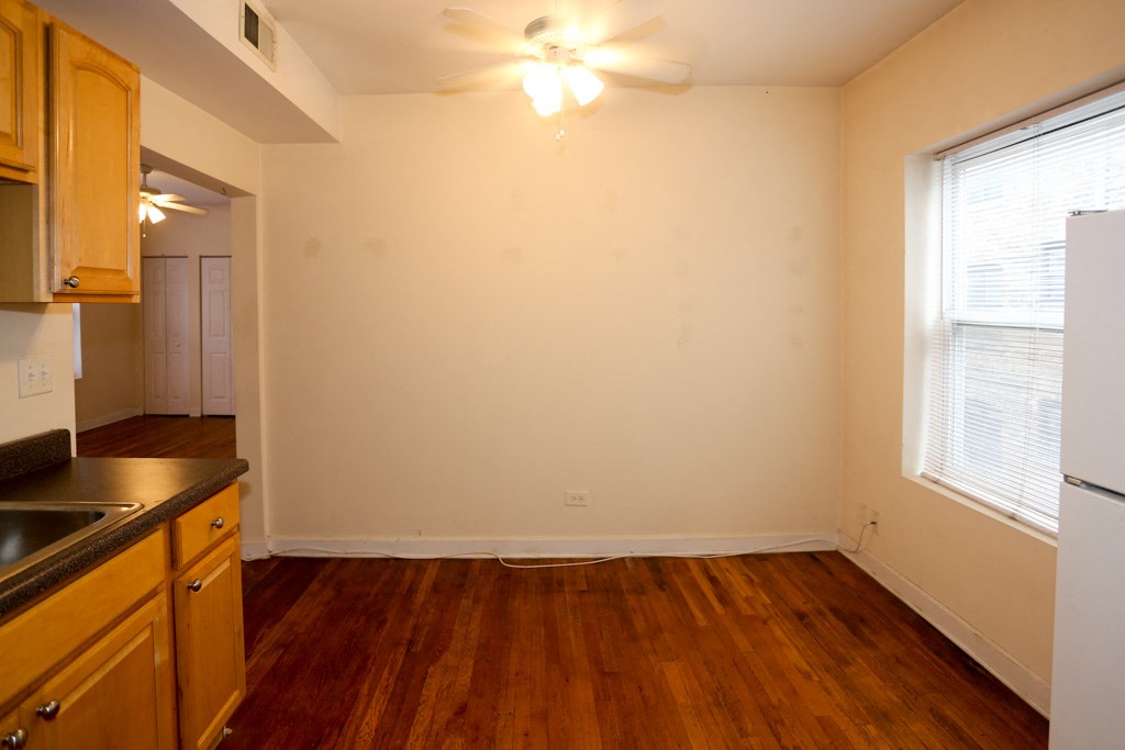 the view of a kitchen and living room with wood flooring and a large window