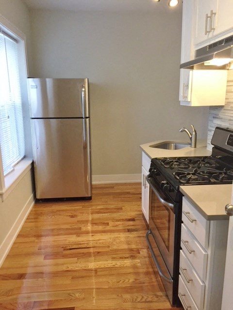 a kitchen with a stainless steel refrigerator and wooden floors