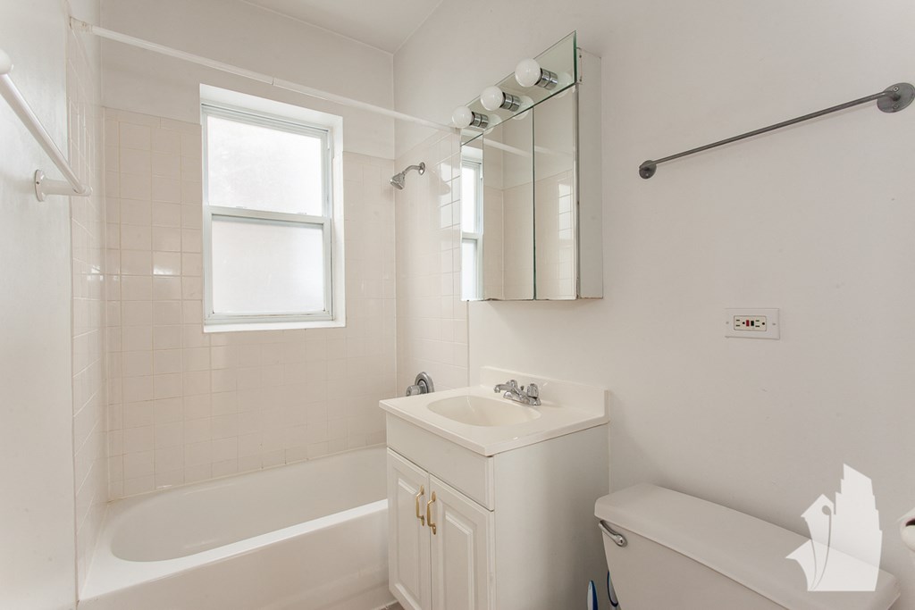 a white bathroom with a tub and sink and a toilet