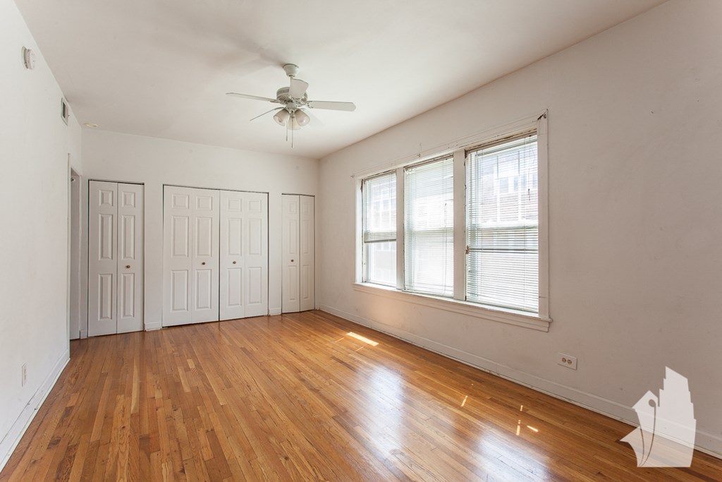 the living room of an empty house with wood floors and a ceiling fan