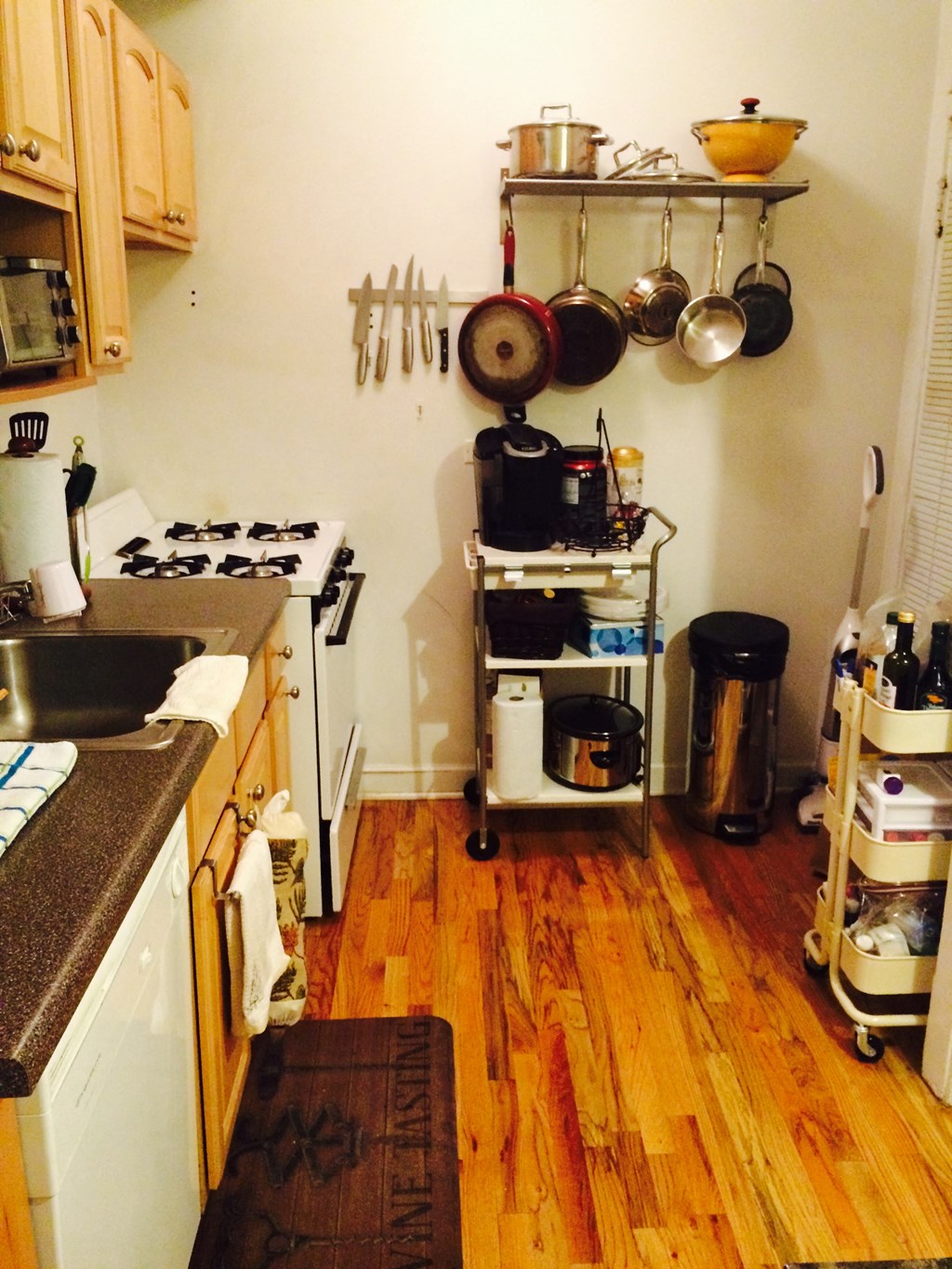 a small kitchen with a wooden floor and pots and pans