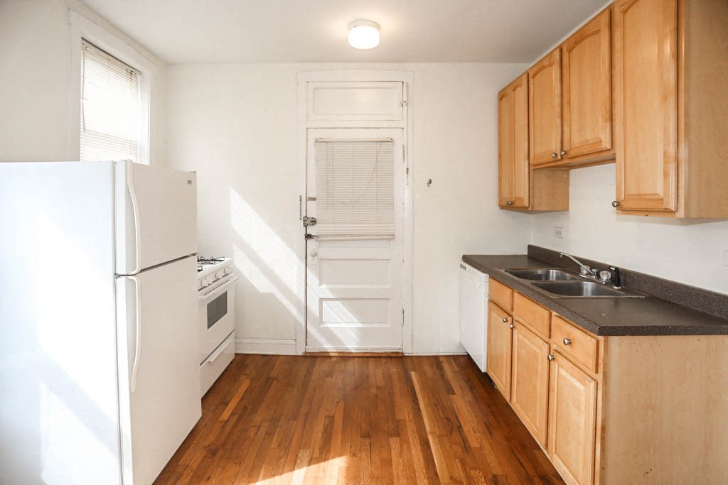 an empty kitchen with a refrigerator and a sink