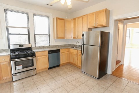 a kitchen with wooden cabinets and a stainless steel refrigerator