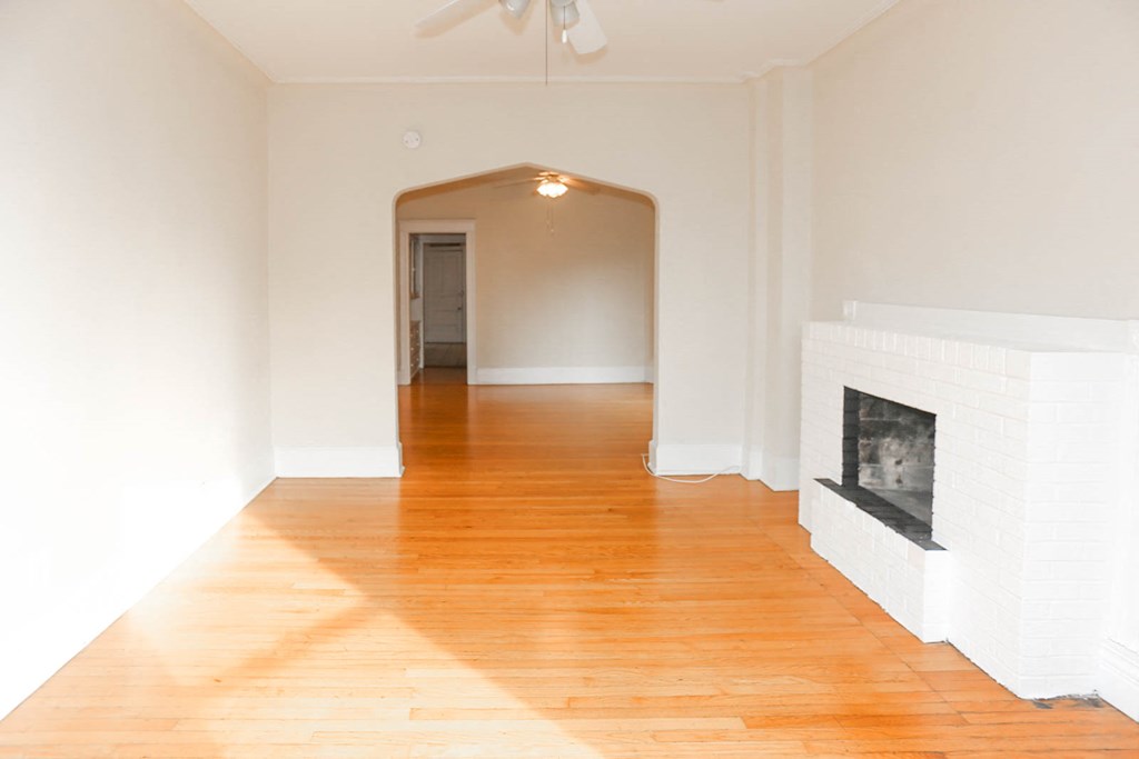 a living room with a fireplace and a wooden floor