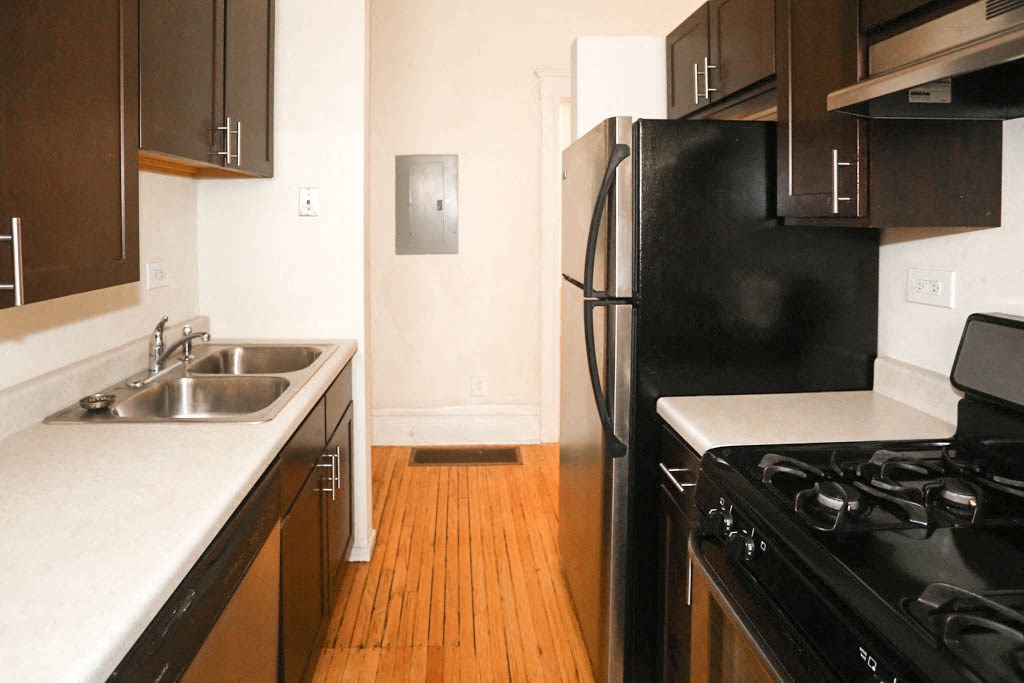 a kitchen with a black refrigerator and a sink