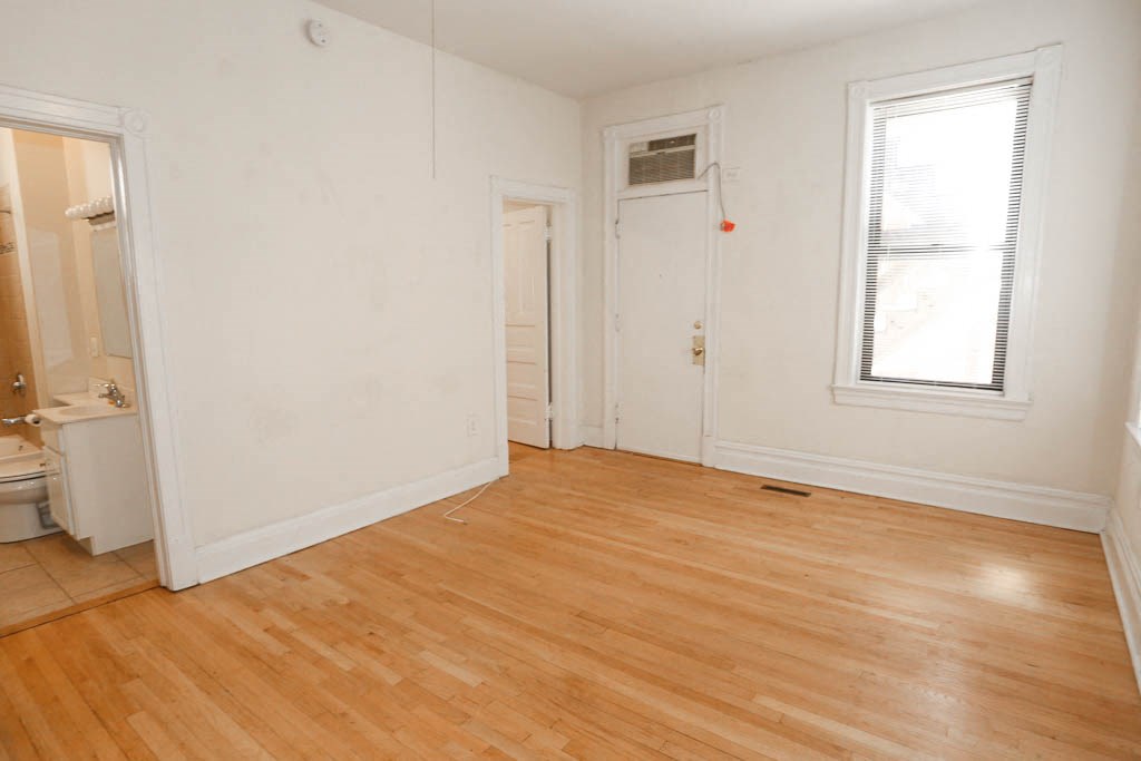 a room with a wood floor and a door and a window