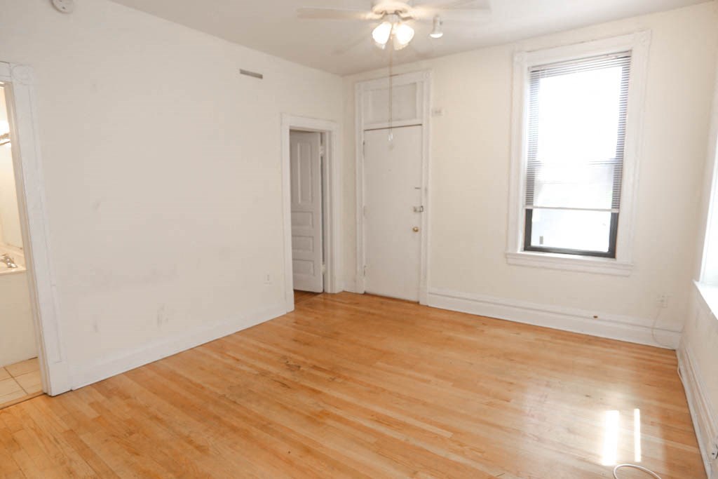 an empty living room with white walls and a wooden floor