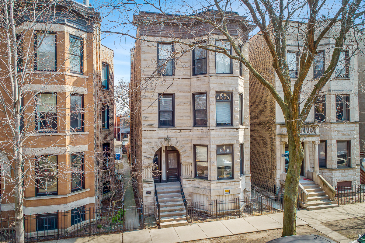 the apartment building has a brick facade and a brown door