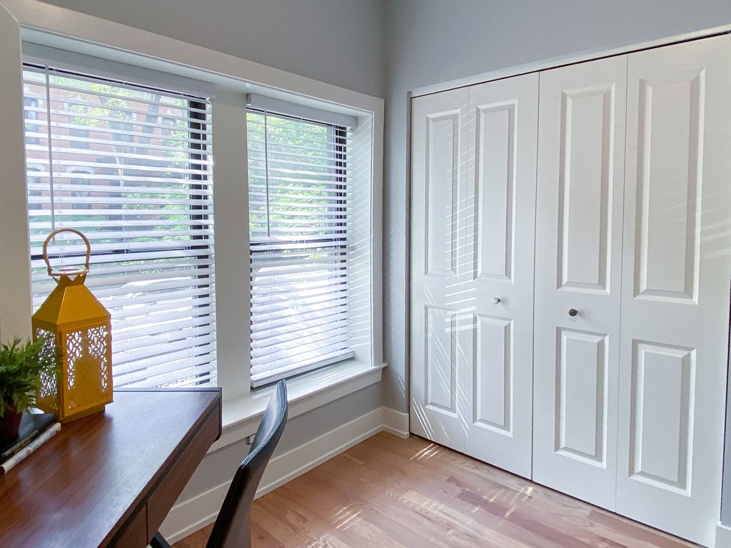 a dining room with white doors and windows and a table and chairs
