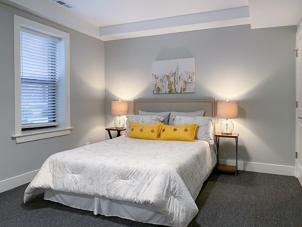 a bedroom with a white bed and yellow pillows