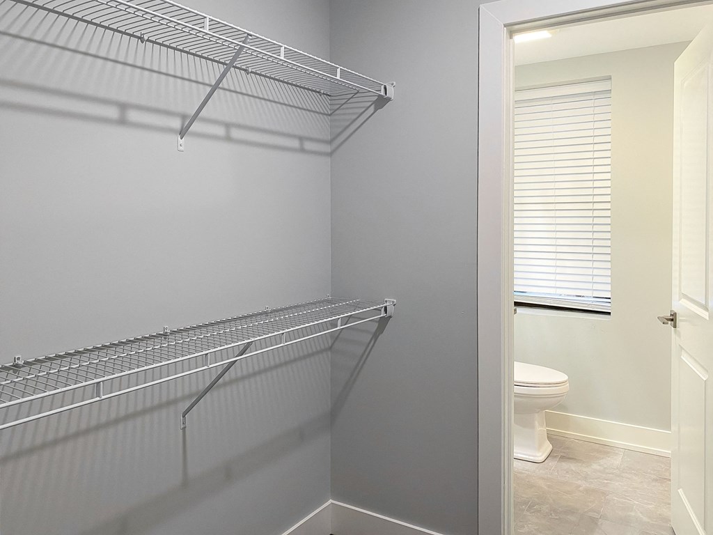 an empty closet in a bathroom with a shower and a toilet